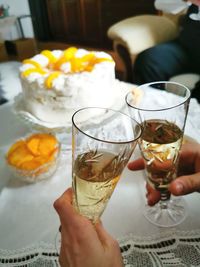 Cropped image of hand holding drink on table