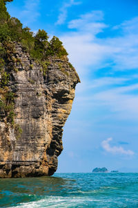 Rock formations by sea against sky