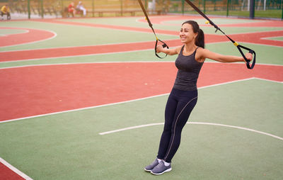 Full length of woman playing with umbrella