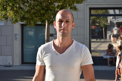 Portrait of mid adult man standing on street in city