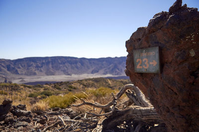 View of sign on landscape against clear sky