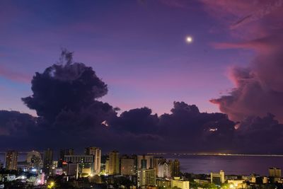Illuminated buildings against sky at night