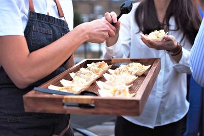 Midsection of woman holding food on table