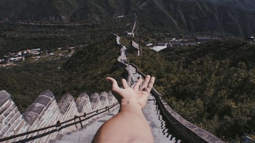 Cropped hand of man against great wall of china