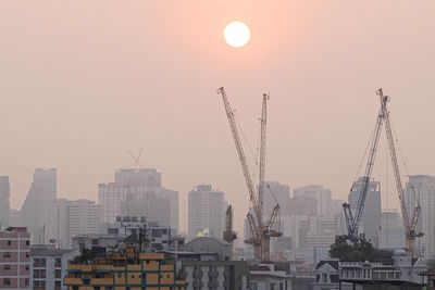 Buildings in city against sky during sunset