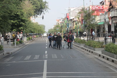 Group of people walking on road in city