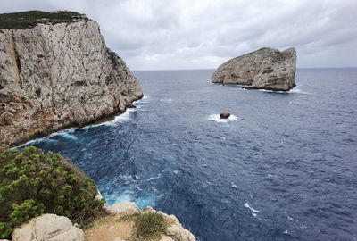 Scenic view of rocks in sea against sky