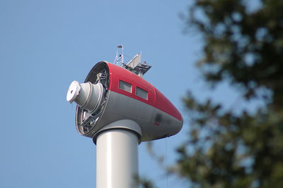 Low angle view of communications tower against clear blue sky