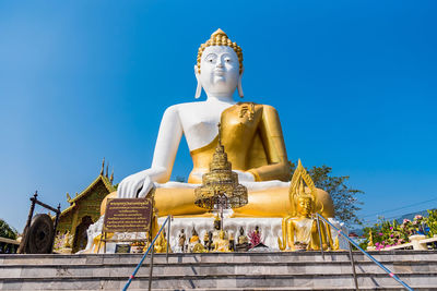 Low angle view of statue against temple against sky