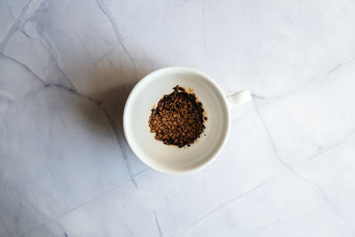 White mug with instant coffee on concrete background. morning breakfast