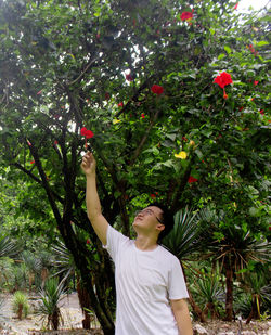 Young woman standing on tree against plants