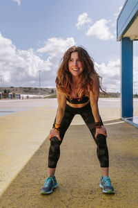 Portrait of smiling young woman against sky