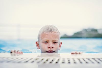 Portrait of confident boy swimming in pool