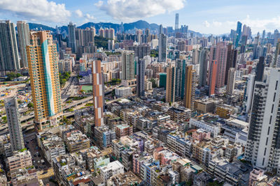 Aerial view of buildings in city against sky