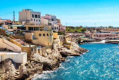 Buildings on coast against clear sky