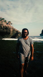 Portrait of young man standing against sky