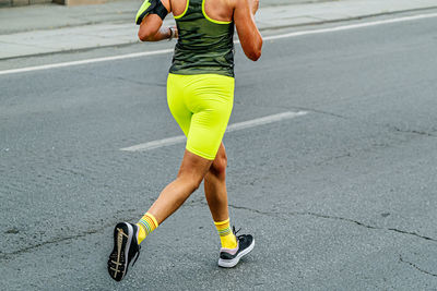 Low section of woman walking on road