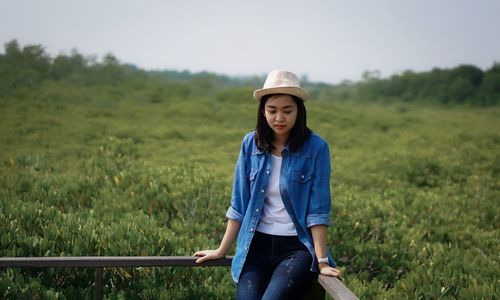 Portrait of young woman standing on field