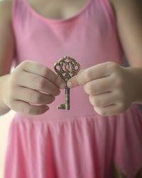 Close-up of hand holding pink flower