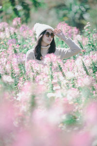 Smiling woman standing by flowering plants