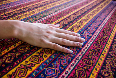 Close-up of woman hand on rug
