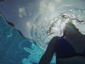 Low section of person swimming in pool