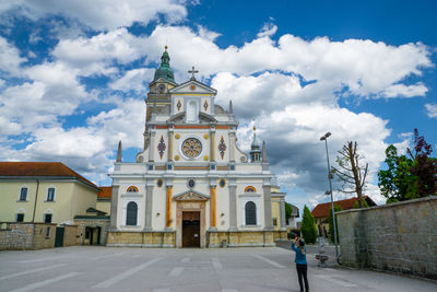 Woman standing against basilica of mary help of christians at brezje