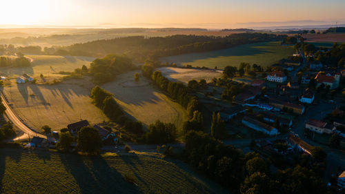 High angle view of houses and buildings against sky during sunrise 