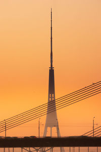 A beautiful riga cityscape with suspension bridge over the river during colorful sunrise. 