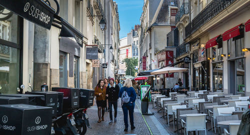 People walking on street amidst buildings in city