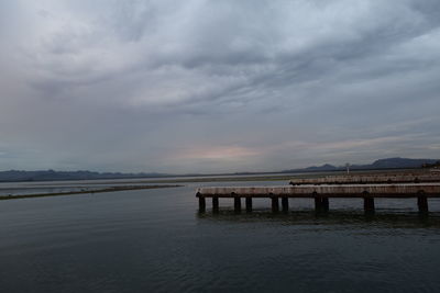 Pier over sea against sky at sunset