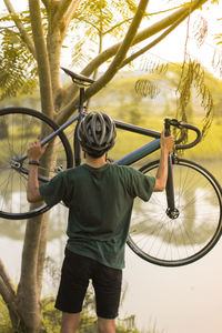 Rear view of boy standing on landscape against trees