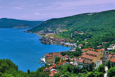 High angle view of townscape by sea against sky