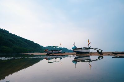 Boats in lake against sky