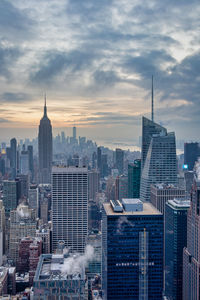 Modern buildings in city against cloudy sky