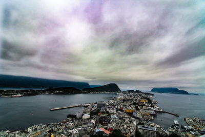 High angle view of city by sea against sky