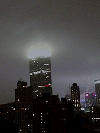 Illuminated cityscape against sky at night