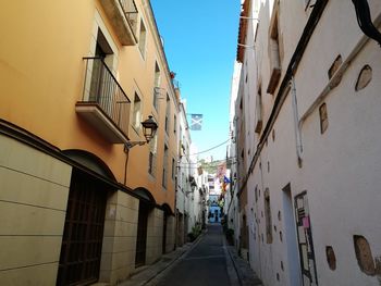 Narrow street amidst buildings against sky