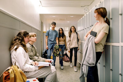 Male and female students in illuminated corridor