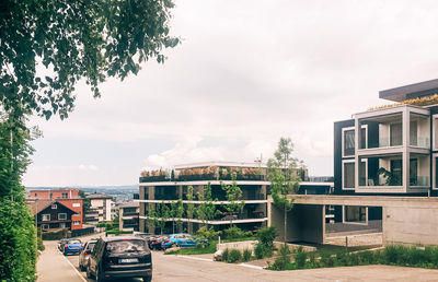 Houses by buildings against sky