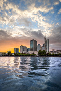 Sunset behind the skyline of frankfurt. cityscape on the river with the financial district.