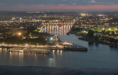 High angle view of rhine river in illuminated city at dusk