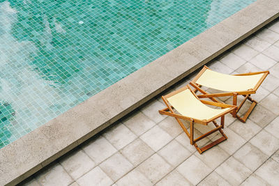 High angle view of chair by swimming pool