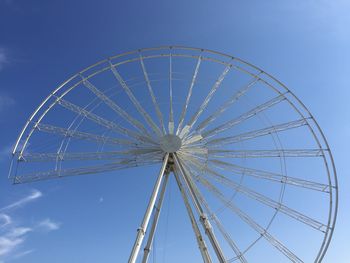 Low angle view of ferris wheel against blue sky