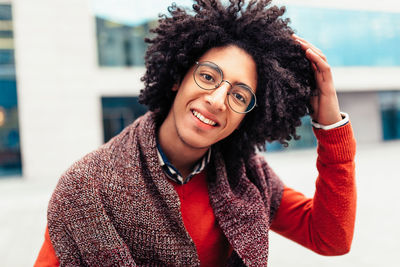 Portrait of smiling young man with hand in hair