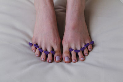 Close-up of female feet painted grey nail polish, self made pedicure at home.