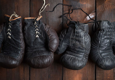 Directly above view of black leather boxing gloves on wooden table