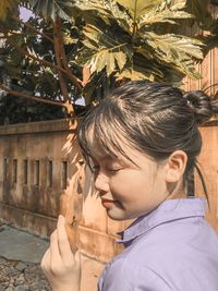 Close-up of woman holding leaf outdoors