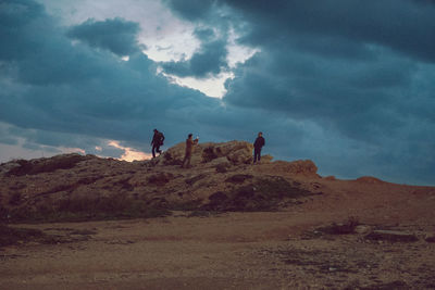 Low angle view of people on mountain against sky