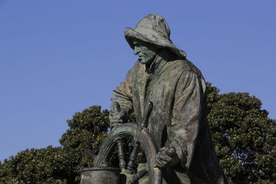 Low angle view of statue against blue sky